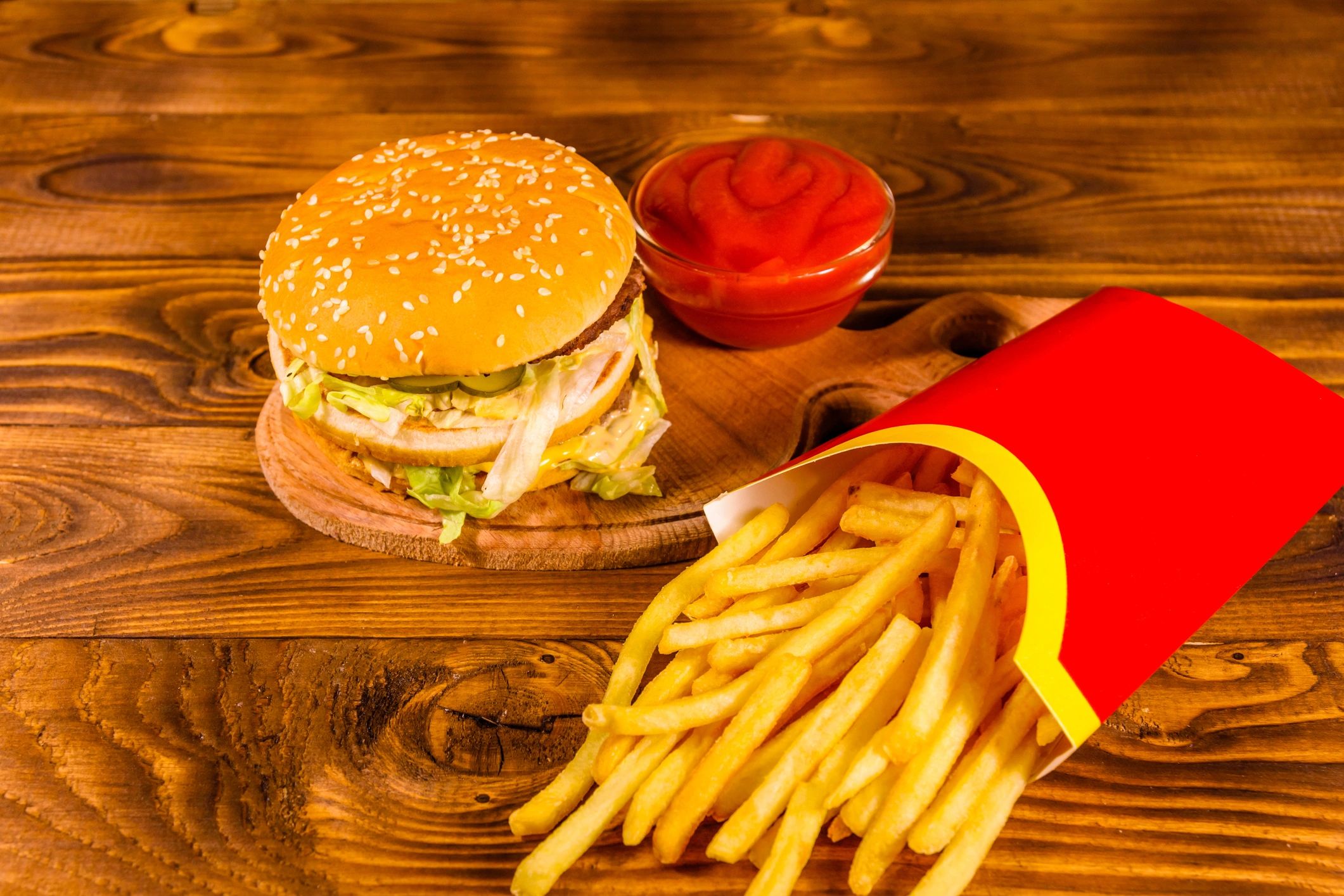 Hamburger and fries on wooden table